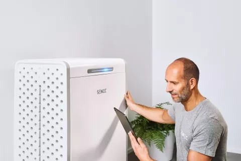 Ein Installateur kontrolliert die Dimensionierung eines Photovoltaik-Speichers mit seinem Tablet.